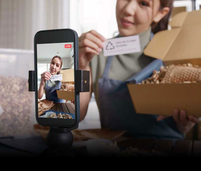 A lively female influencer broadcasts live from her phone, demonstrating a product and engaging her viewers with energetic, real-time interaction.