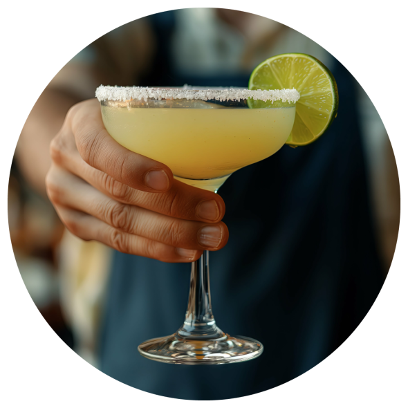 A male bartender presenting a freshly made margarita with a lime garnish.