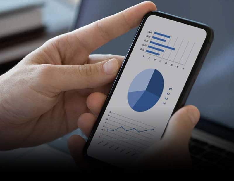 Person using a mobile phone to view financial charts and market data.